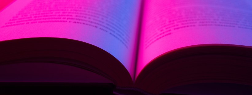 Open book with light over dark background